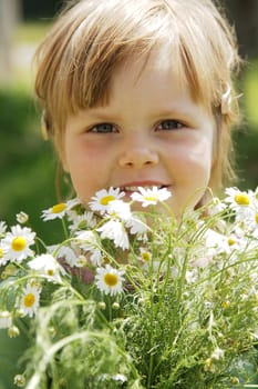 Cute little girl with white daisies outdoor