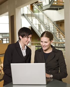 Two businesswomen in front of a laptop