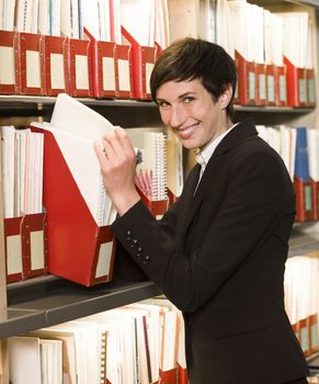 Smiling woman searching at an archive