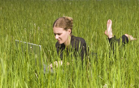 Woman with her computer in the grass