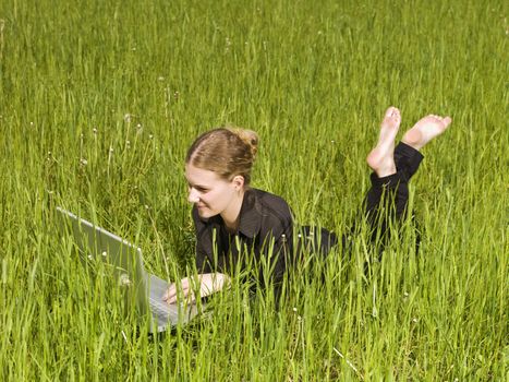 Woman with her computer in the grass