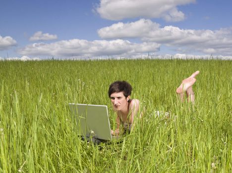 Woman with her computer in the grass