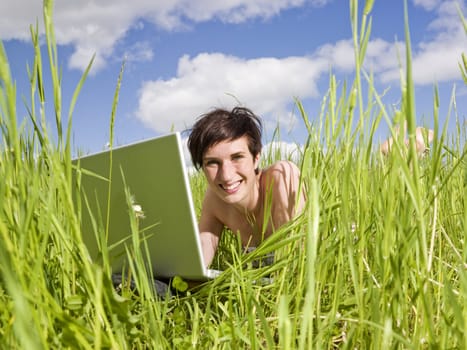 Smiling Woman with her computer in the grass