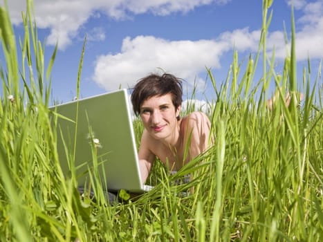 Woman with her computer in the grass