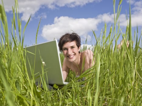 Woman with her computer in the grass