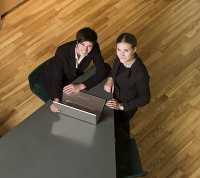 Two women from above with a computer