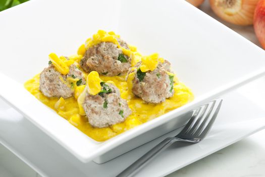 minced meat and herbs balls in apple and curry sauce