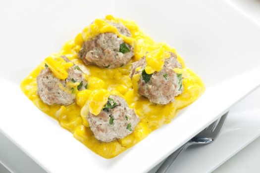 minced meat and herbs balls in apple and curry sauce