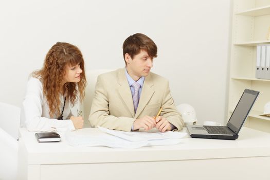 Pair of young businessmen work at office with the laptop