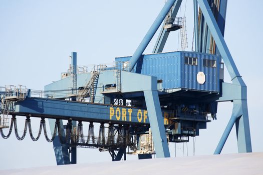 Closeup photo of big crane at the port on a sunny day.