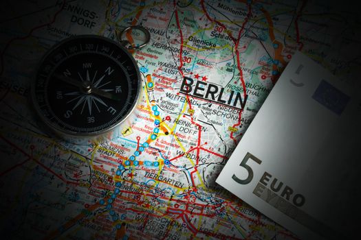 Compass and five euros on a map of Berlin