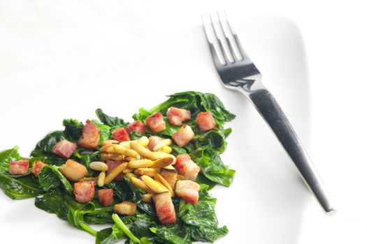 fried spinach with bacon and pine nuts