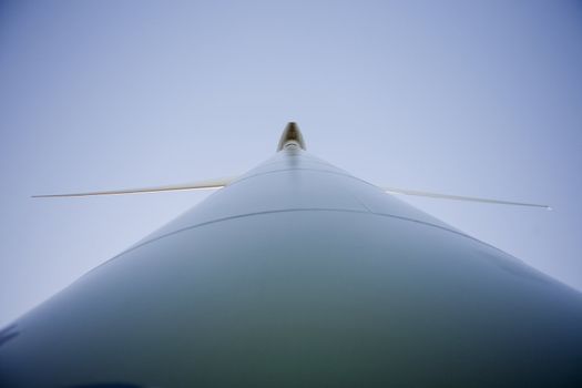 Closeup picture of a modern windmill producing renewable energy ecologically.