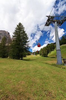 cablaway over meadow and wood in Italian Dolomites