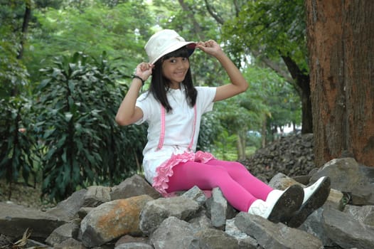 little asian girl sit down in park