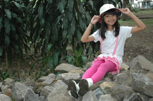 little asian girl sit down in park