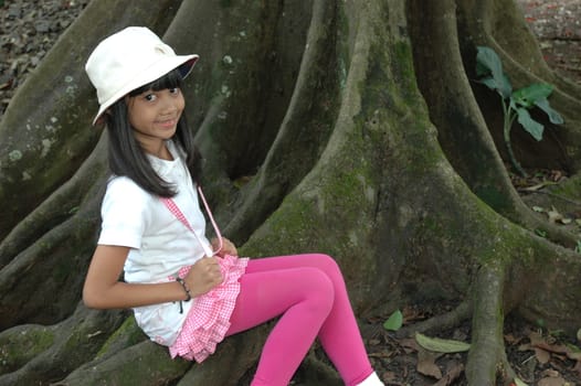 little asian girl sit down in park