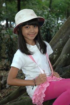 little asian girl sit down in park