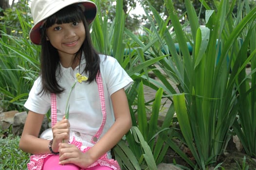 little asian girl sit down in park