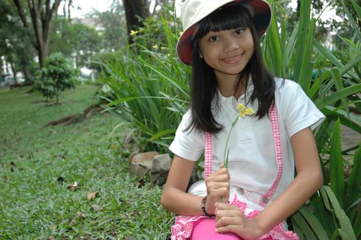 little asian girl sit down in park