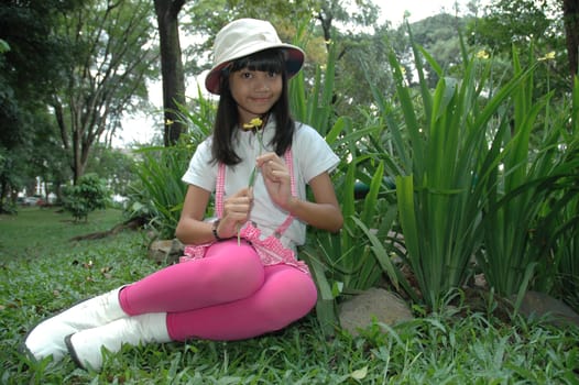 little asian girl sit down in park