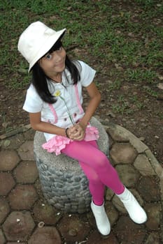 little asian girl sit down in park