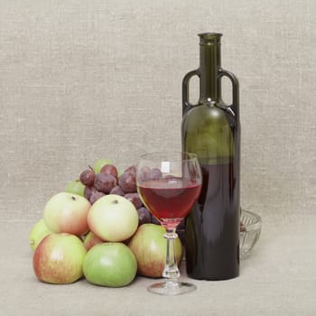 Still-life from a bottle of wine and fruit against a canvas