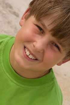 Smiling boy wearing a green t-shirt - angled.