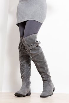 detail of standing woman wearing fashionable gray boots