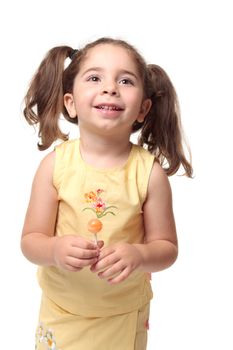 Happy laughing child in yellow outfit and hair in pigtails