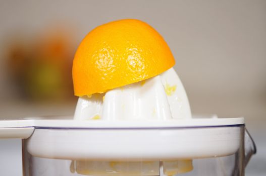 Squeezing of orange juice on a juice extractor