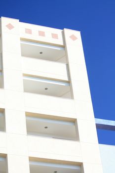 Detail of an off white apartment building and a clear blue sky