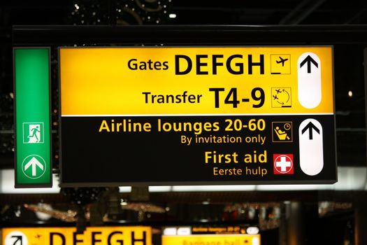 Airport information sign with directions to first aid and gates