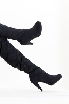 detail of sitting woman wearing fashionable black boots