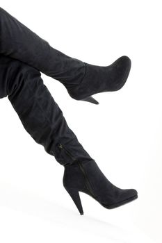 detail of sitting woman wearing fashionable black boots