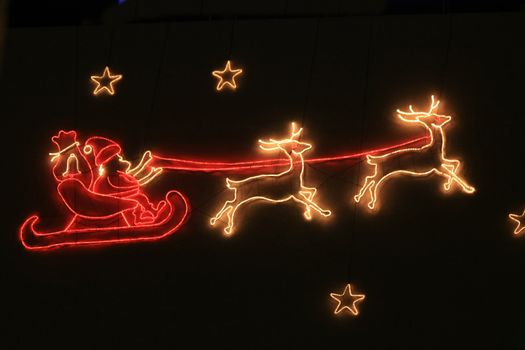 A holiday decoration lightning, santa claus and his sleigh