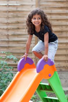 Smiling girl playing on  a slide