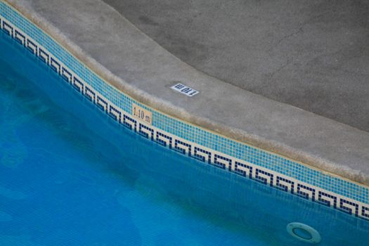 Blue pattern tiles on the edge of a swimming pool