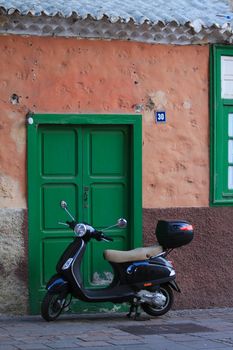 A vintage retro model Vespa scooter in front of an old building