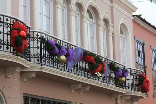 Red and purple christmas decorations on a public building in Tenerife