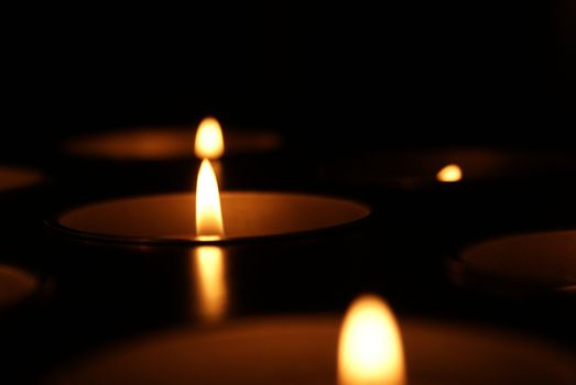 horizontal dark background with many lit candles