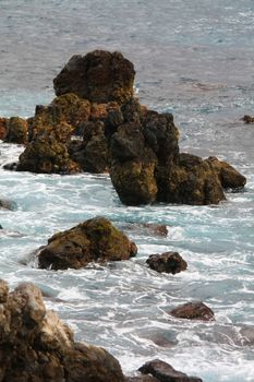 waves breaking on rocks. blue sea and sky.
