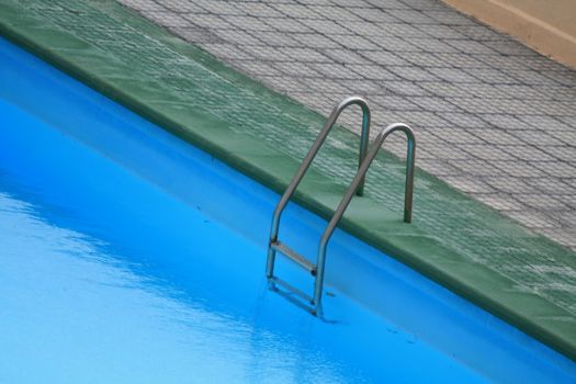 A ladder on the side of a swimming pool