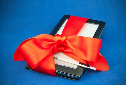 Electronic book reader tied up with red ribbon