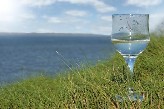 single glass of pure natural water standing on the beach dunes in kerry ireland