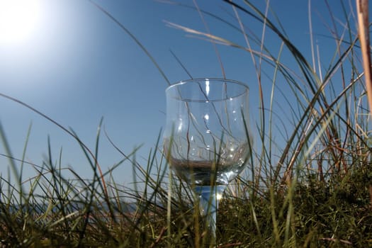 single glass of pure natural water standing on the beach dunes in kerry ireland