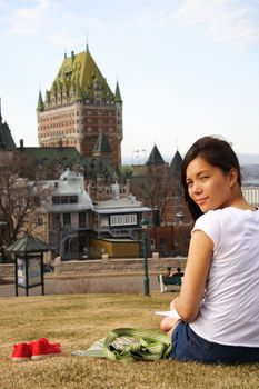 Student relaxing in Quebec City with Chateau Frontenac in the background.