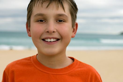 Smiling boy with a soft beach background.