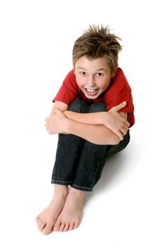 Sitting boy wearing jeans and red t-shirt looking up, happy expression