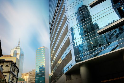 Skyscraper stands on the street with blue sky and white clouds.